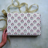 Gift box with floral pattern and ribbon on a neutral background