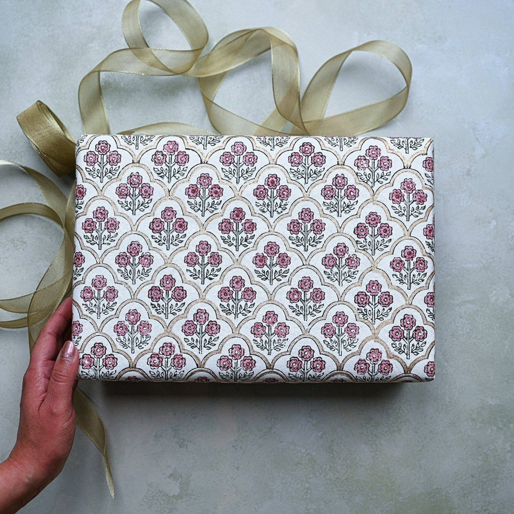 Gift box with floral pattern and ribbon on a neutral background