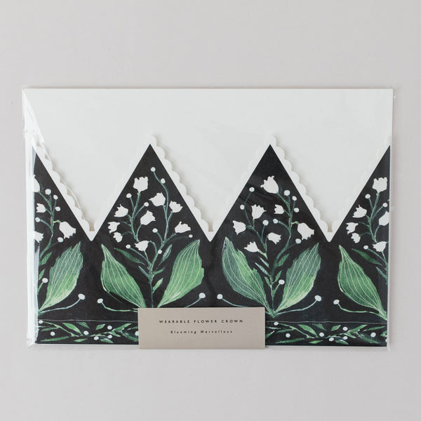 Floral design with green leaves and white flowers on a black background, featuring a beige label.