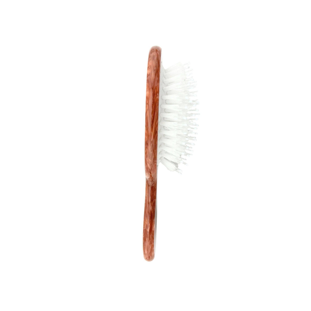 Wooden hairbrush with white bristles on a white background