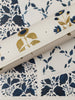 Floral patterned paper with gold sunflower design on a white background