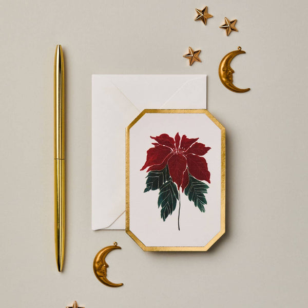 Decorative card with red flower design, gold pen, and decorative elements on a beige background