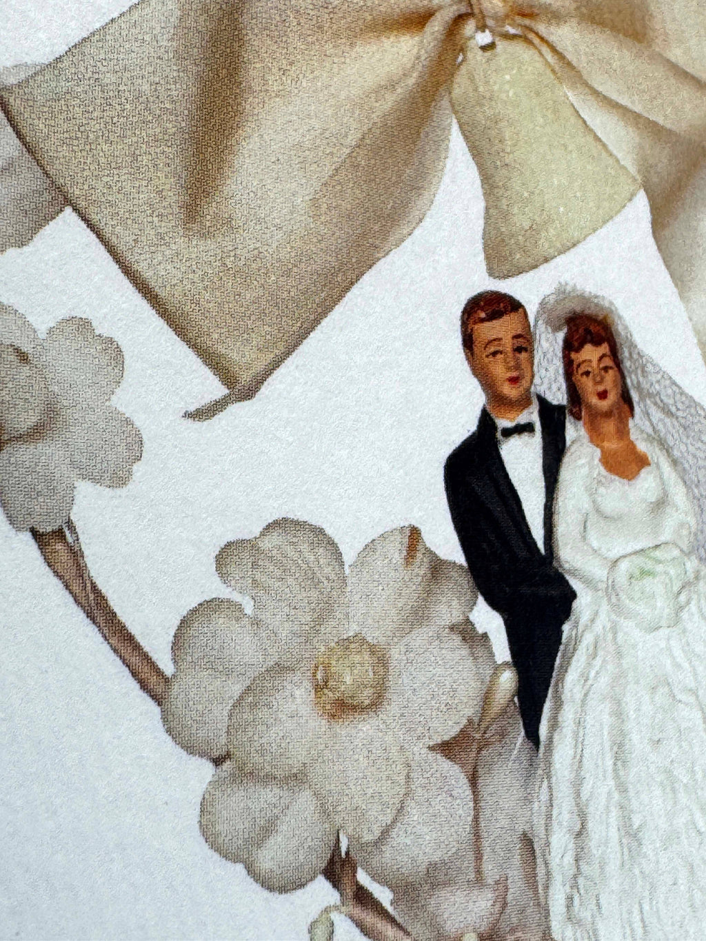 Wedding couple figurine with a large bow and flowers on a white background