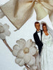 Wedding couple figurine with a large bow and flowers on a white background