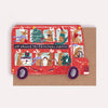 Red Christmas-themed bus with cartoon animals on a brown background