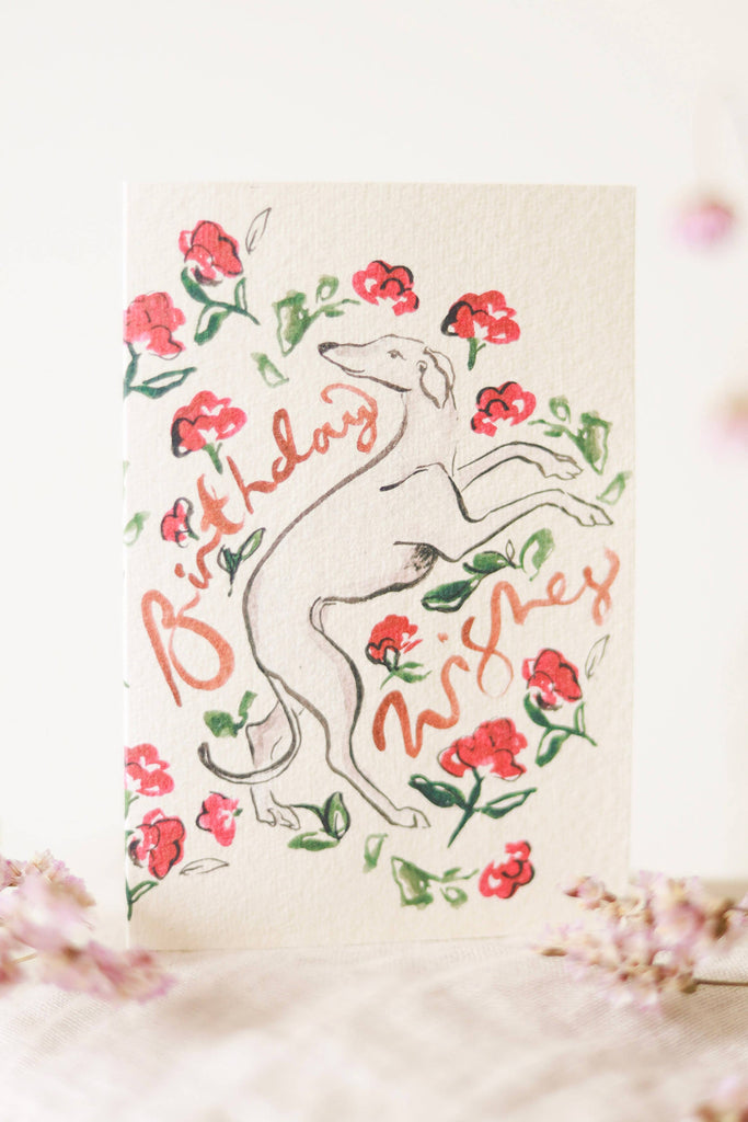 Greeting card with a dog illustration and floral elements on a light background