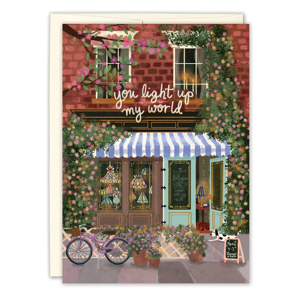 Illustration of a quaint store front with flowers and 'you light up my world' text
