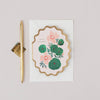 Floral card with gold pen on a light gray background