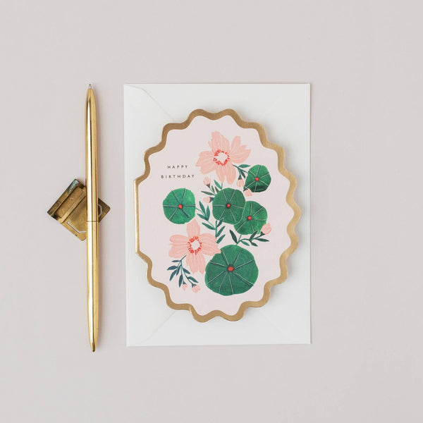 Floral card with gold pen on a light gray background