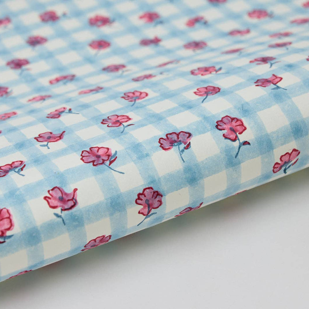 Floral patterned fabric with pink flowers on a blue and white checkered background