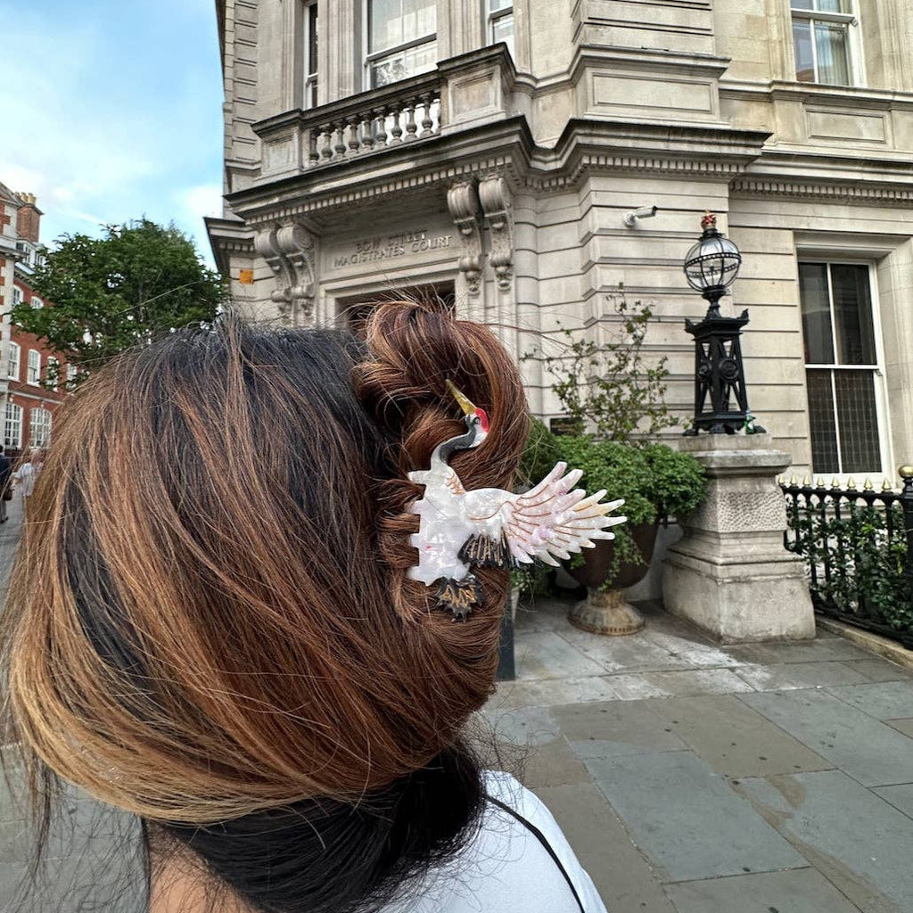Person with a decorative hair clip in front of a large building