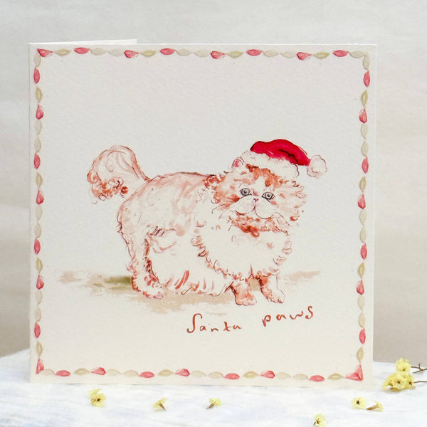 Illustration of a dog wearing a Santa hat on a decorative card with a floral border.