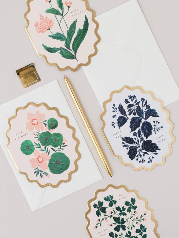 Floral stationery items including cards and an envelope on a light background