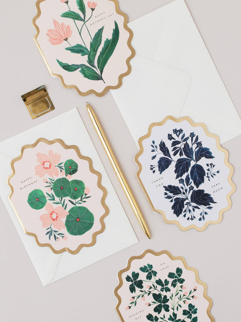 Floral stationery items including cards and an envelope on a light background