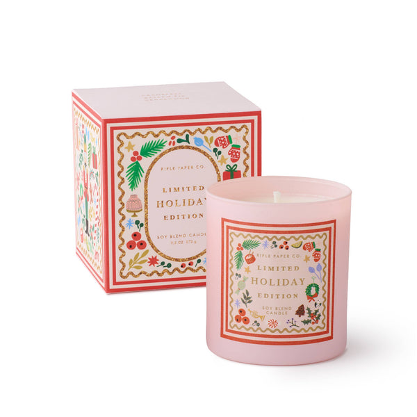 Pink candle with decorative label and matching box on a white background
