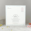 Baby shower invitation card on a gray surface with decorative flowers.