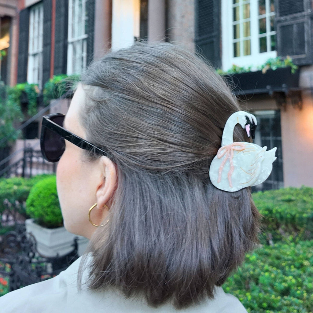 Person with swan hair clip in a city setting