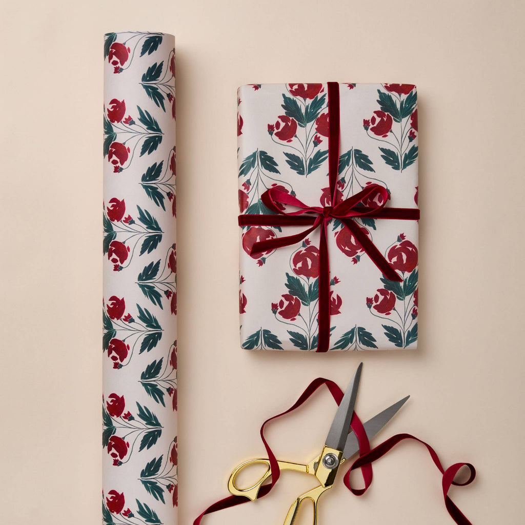 Floral-patterned gift wrap with a wrapped present and scissors on a beige background