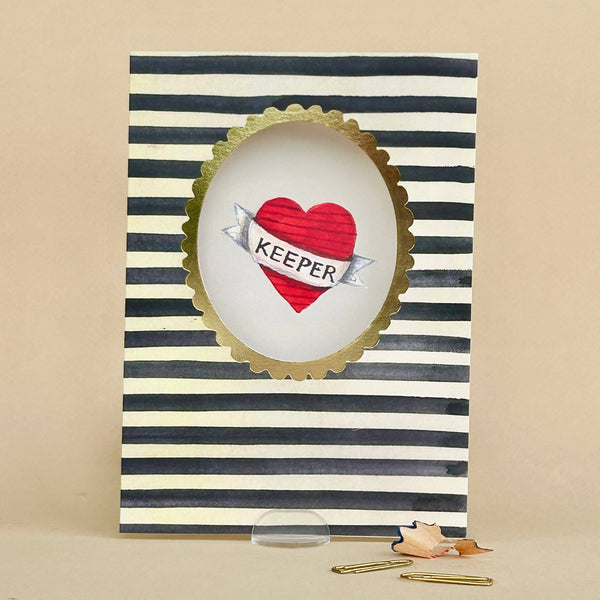 Card with striped border, heart design, and 'KEEPER' text on a beige background