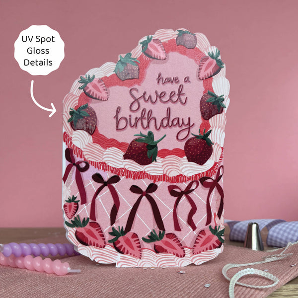 Decorative birthday card with strawberries and ribbons on a pink background