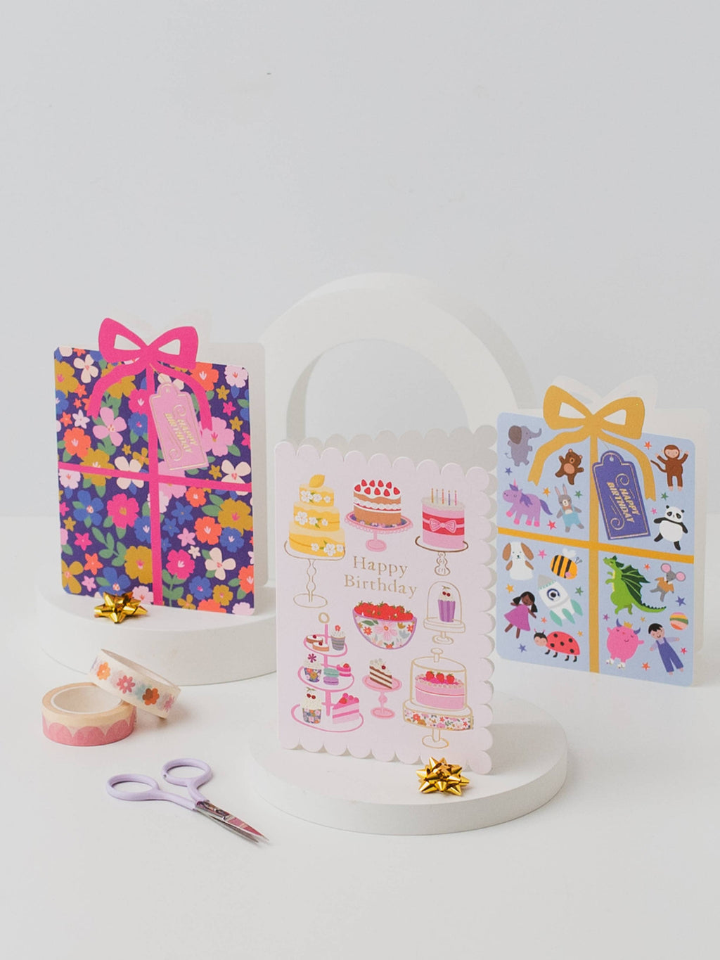 Decorative birthday-themed items including a gift bag, stickers, and washi tape on a white background.