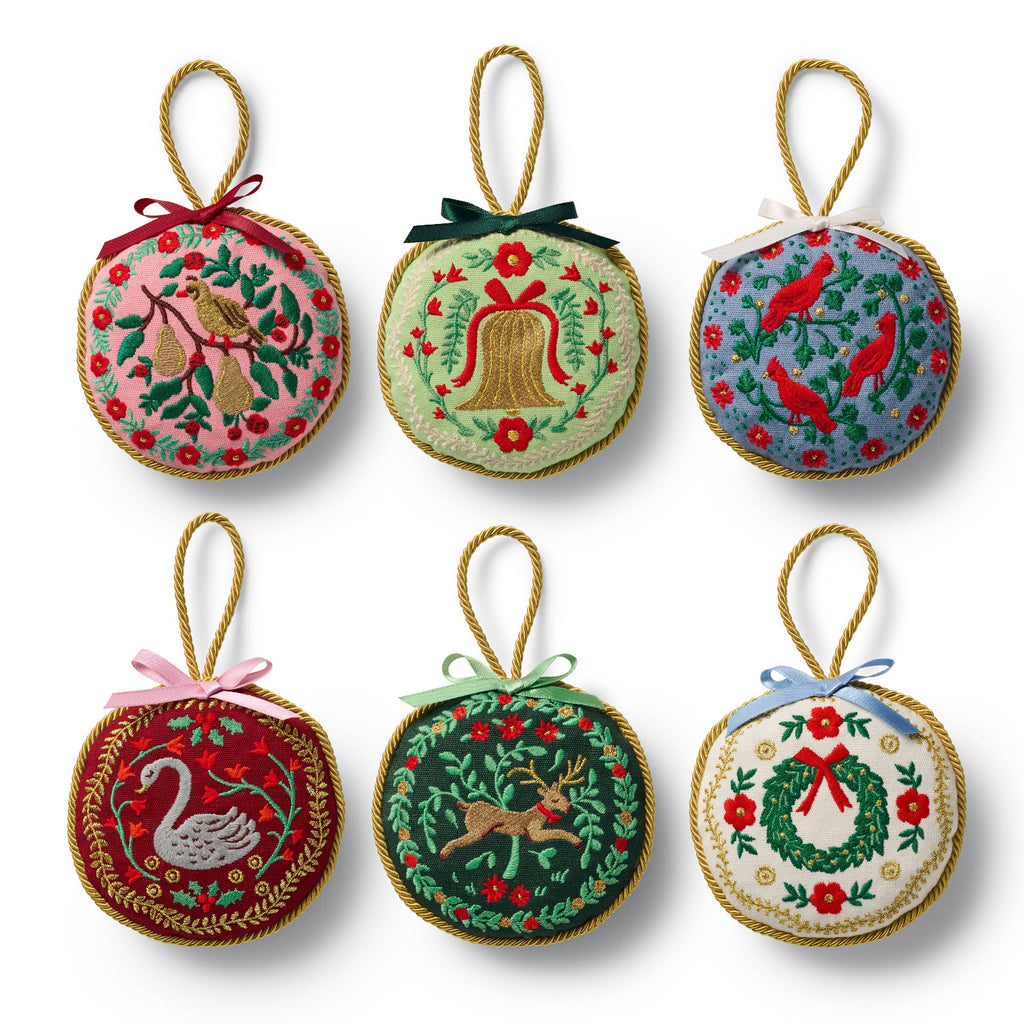 Set of six festive Christmas ornaments with various designs on a white background