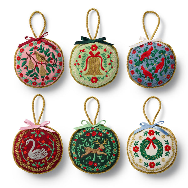 Set of six festive Christmas ornaments with various designs on a white background