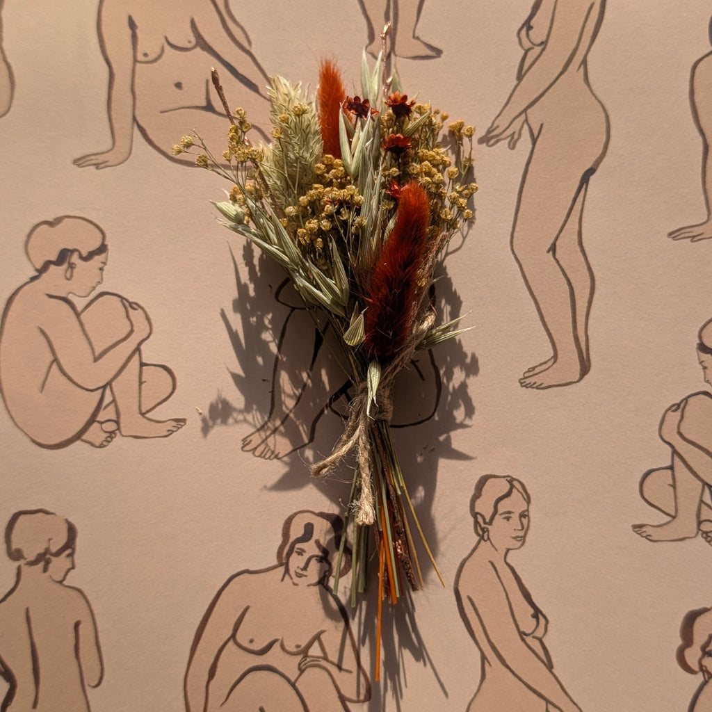 Dried flowers and herbs on a beige background with black line drawings of nude figures.